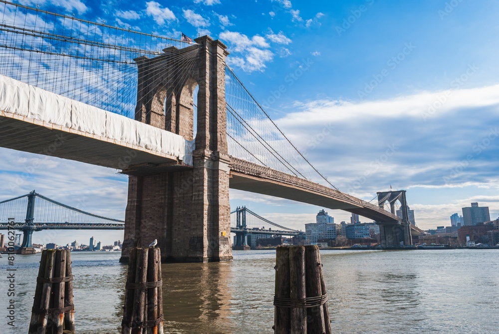The Brooklyn Bridge is a large suspension bridge that spans the East River The Brooklyn Bridge is a large suspension bridge that spans the East River