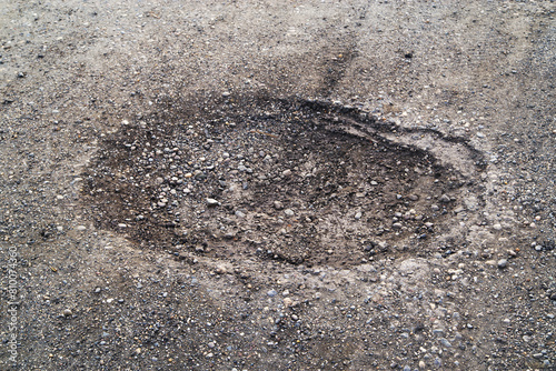Poor condition of the road surface. Spring season. Hole in the asphalt, risk of movement by car, bad asphalt, dangerous road, potholes in asphalt