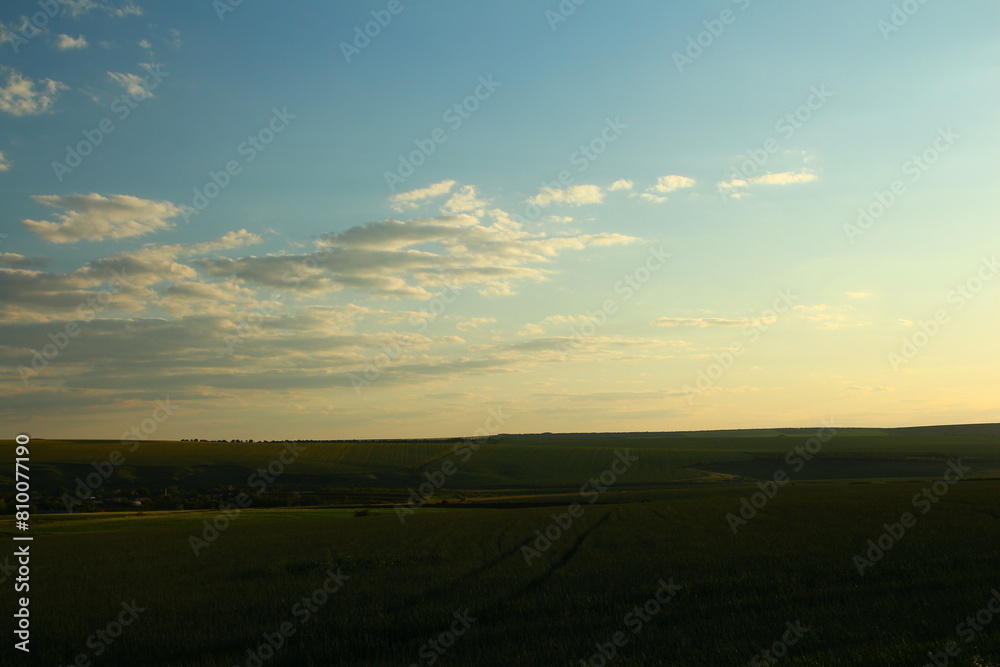 Fototapeta premium A landscape with a road and blue sky with clouds