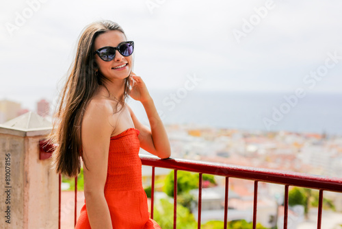 young Hispanic woman enjoying vacation on coast overlooking ocean