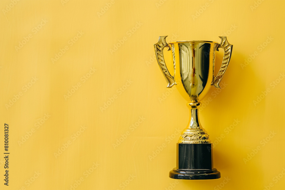 A golden trophy against a yellow background is a striking image of success and achievement A golden trophy against a yellow background is a striking image of success and achievement