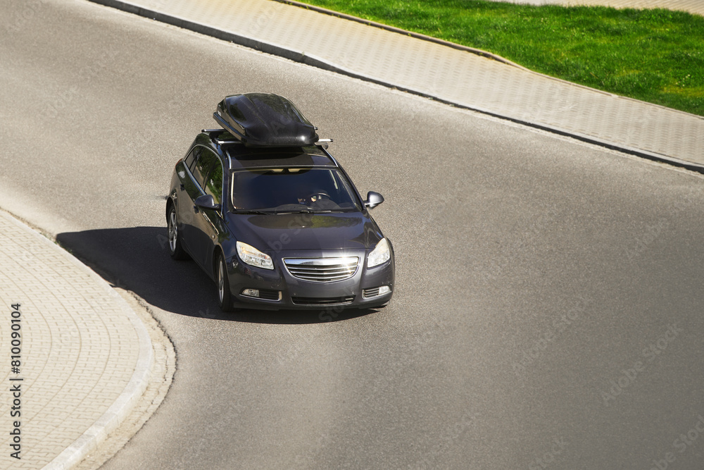 Car equipped with a rooftop cargo carrier amidst heavy traffic on a sunny day Car equipped with a rooftop cargo carrier amidst heavy traffic on a sunny day