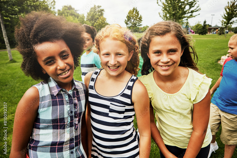 Obraz premium Children, park and portrait of group in playground to relax with friends on field on vacation. Happy, holiday and kids together for party, games or smile outdoor at middle school on break at recess