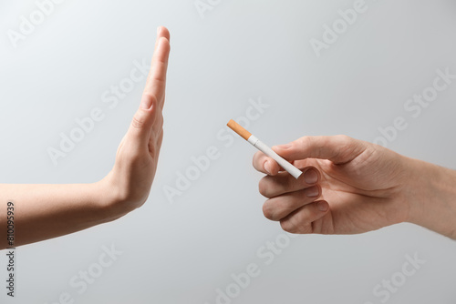 Man refusing cigarette on grey background  closeup