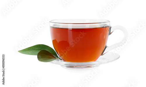 Tasty tea in cup and green leaves isolated on white
