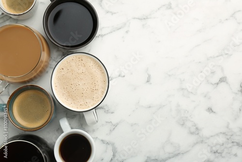Different coffee drinks in cups on white marble table  flat lay. Space for text