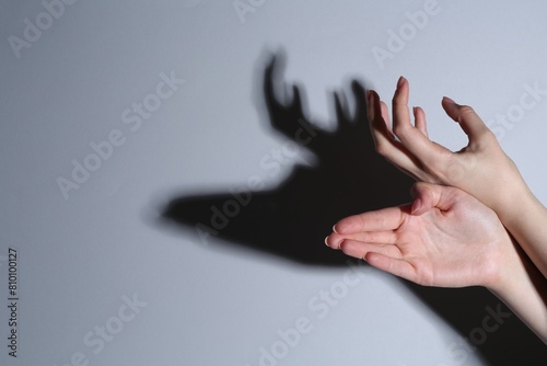 Shadow puppet. Woman making hand gesture like deer on grey background, closeup. Space for text