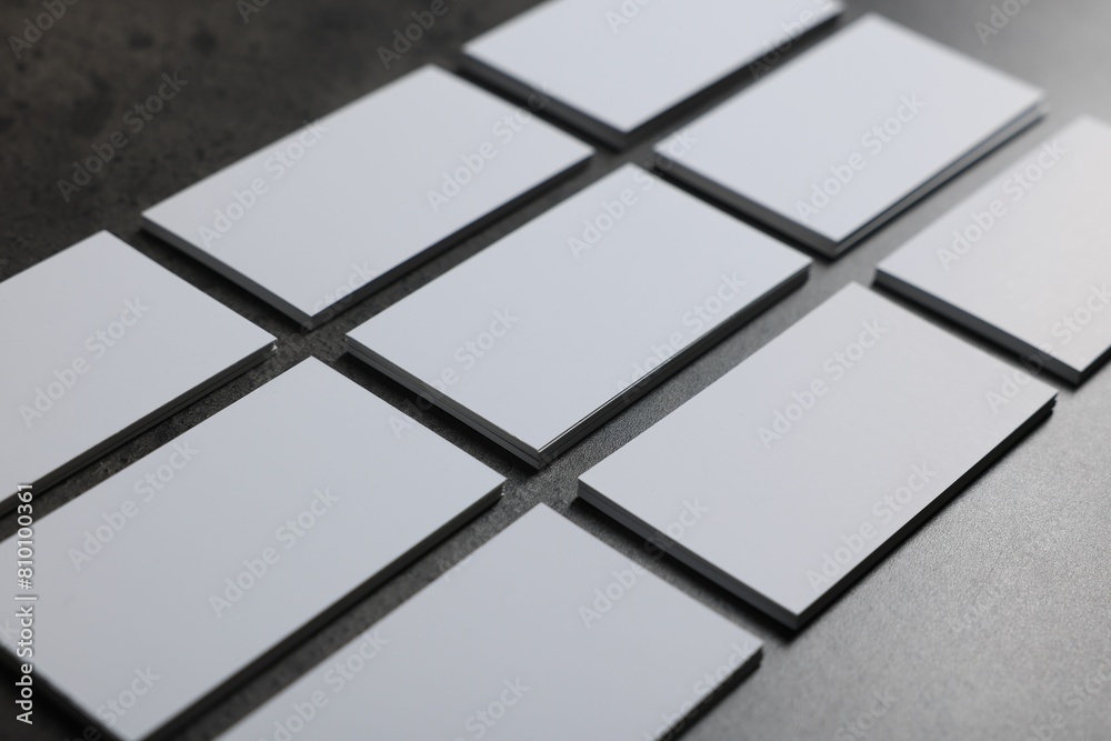 Obraz premium Blank business cards on grey textured table, closeup. Mockup for design