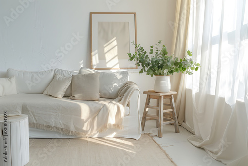 A bright and airy living room with a white sofa, soft beige rug on the floor, wooden side table holding greenery, large window draped in sheer curtains. A framed picture hangs above the couch. © gamespirit