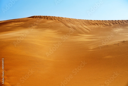 Sand fall. Sand landslide from the crest of a red dune  iron oxide  as a result of increased load  but not the wind . Barkhan in the Arabian Desert.