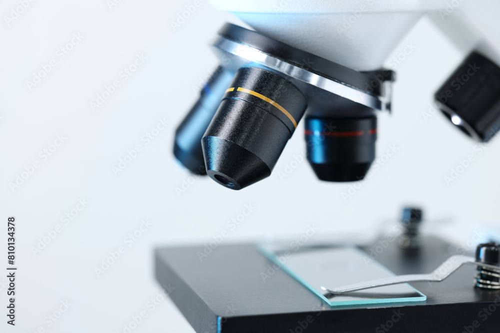 Modern microscope on light background, closeup view Modern microscope on light background, closeup view