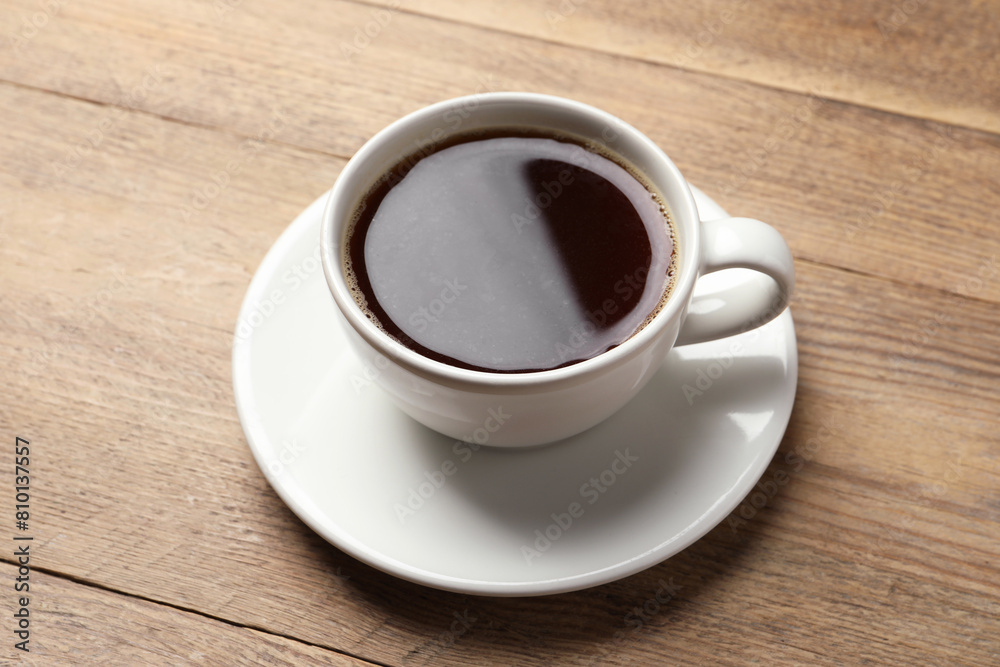 Cup of aromatic coffee on wooden table