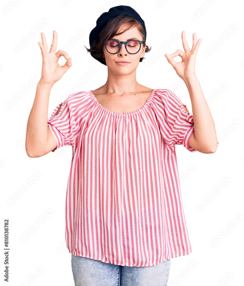Beautiful young woman with short hair wearing casual clothes and glasses relax and smiling with eyes closed doing meditation gesture with fingers. yoga concept. Beautiful young woman with short hair wearing casual clothes and glasses relax and smiling with eyes closed doing meditation gesture with fingers. yoga concept.