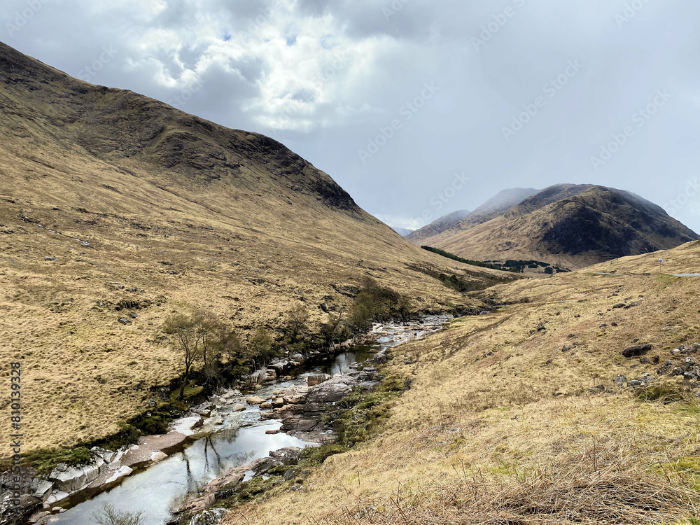 A view of the Scotland Countryside near the Glencoe Mountains on a sunny day A view of the Scotland Countryside near the Glencoe Mountains on a sunny day