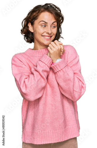 Young hispanic woman wearing casual clothes laughing nervous and excited with hands on chin looking to the side