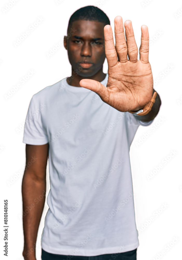 Young african american man wearing casual white t shirt doing stop sing with palm of the hand. warning expression with negative and serious gesture on the face. Young african american man wearing casual white t shirt doing stop sing with palm of the hand. warning expression with negative and serious gesture on the face.