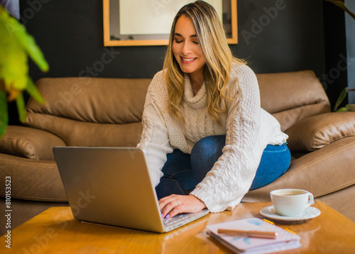 mujer ejecutiva sentada en el sofá trabajando en el computador portátil 