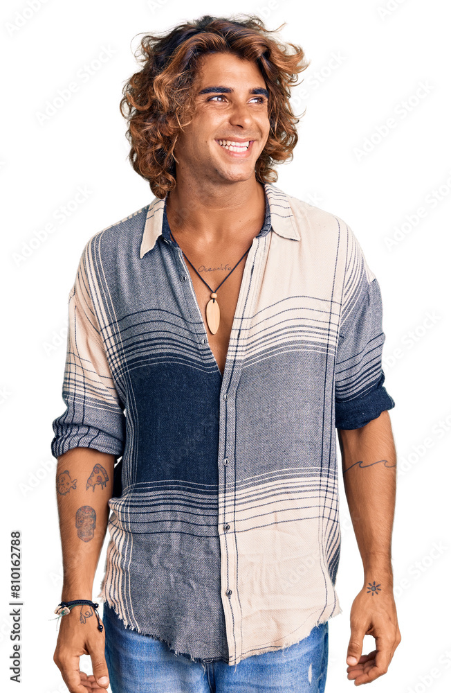 Young hispanic man wearing summer style looking away to side with smile on face, natural expression. laughing confident. Young hispanic man wearing summer style looking away to side with smile on face, natural expression. laughing confident.