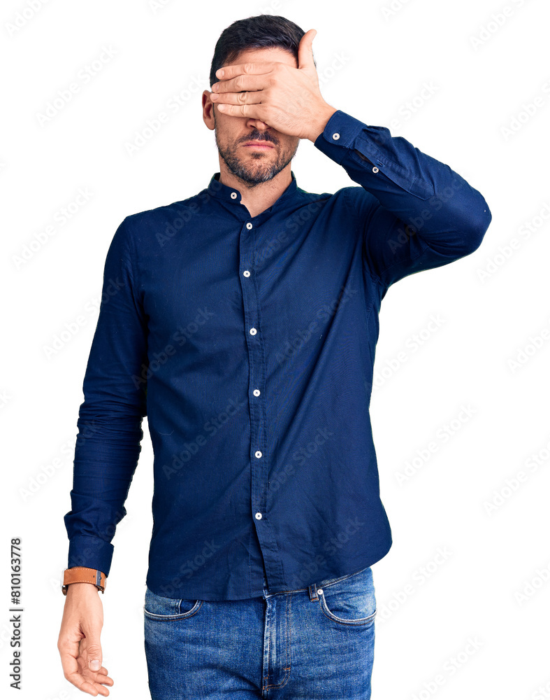 Young handsome man wearing casual shirt covering eyes with hand, looking serious and sad. sightless, hiding and rejection concept Young handsome man wearing casual shirt covering eyes with hand, looking serious and sad. sightless, hiding and rejection concept