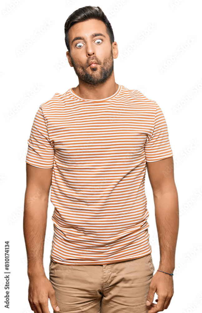 Handsome hispanic man wearing casual clothes making fish face with lips, crazy and comical gesture. funny expression. Handsome hispanic man wearing casual clothes making fish face with lips, crazy and comical gesture. funny expression.