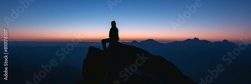 Silhouette mountain zenith framed evening sky solitary observer nature's grandeur