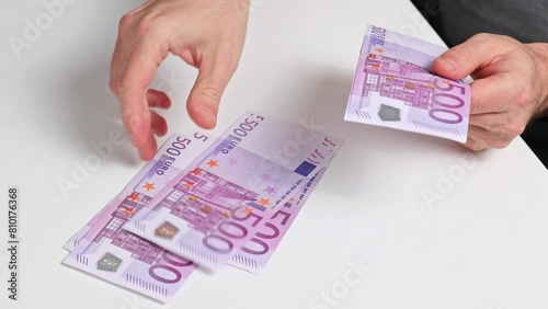 Hands counts European 500 (five hundred) EURO money banknotes one on top of the other. 500 Euro banknote counting. photo