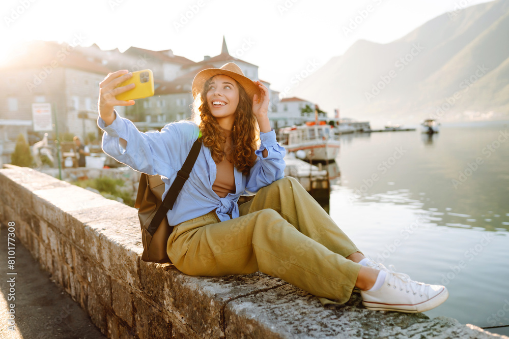 Fototapeta premium Female tourist taking selfie photos on sightseeing. Selfie time. Lifestyle, adventure, nature, active life.