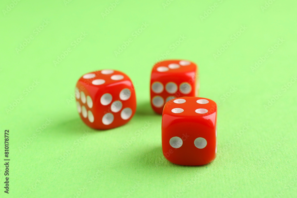 Three red game dices on green background, closeup Three red game dices on green background, closeup