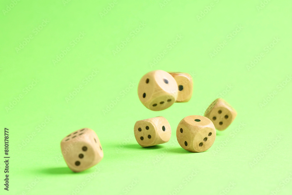 Many wooden game dices falling on green background Many wooden game dices falling on green background