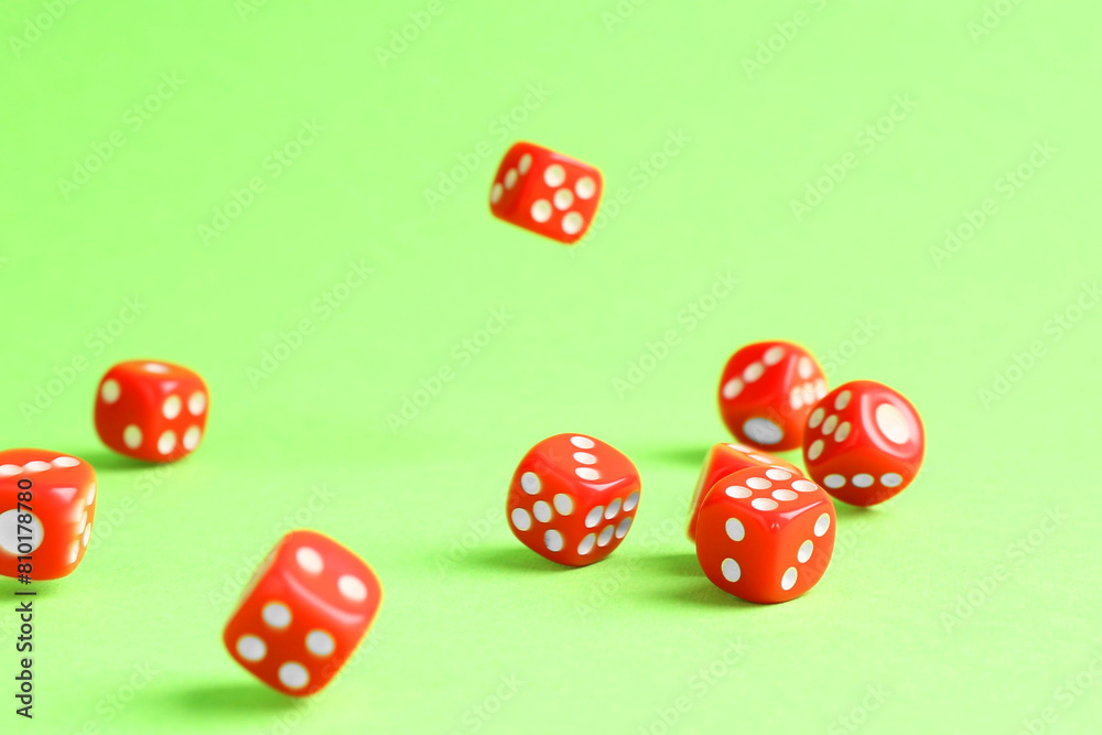 Many red game dices falling on green background Many red game dices falling on green background