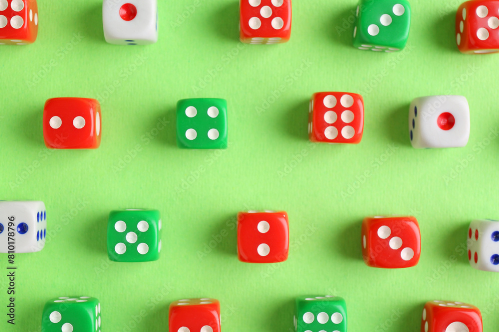 Many color game dices on green background, flat lay Many color game dices on green background, flat lay