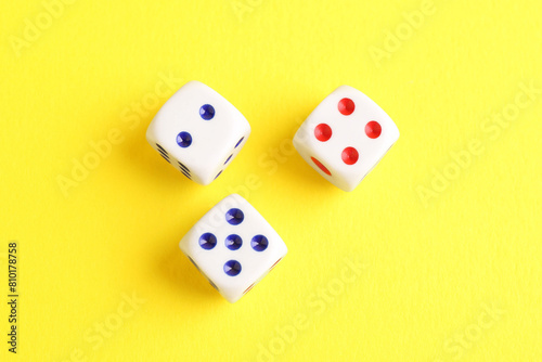 Three white game dices on yellow background  flat lay. Space for text