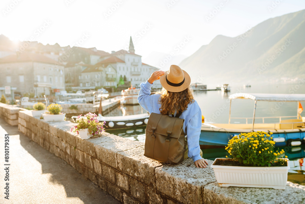 Tourist woman admiring view of colorful the view of the city. Back view. Europe travel. Lifestyle, vacation, nature, active life.