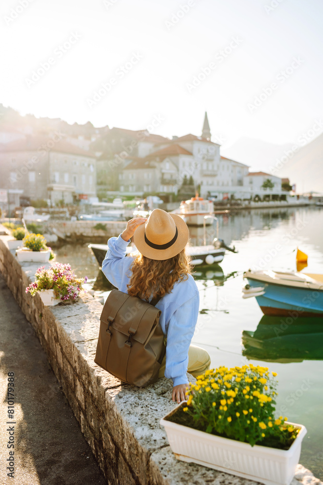Obraz premium Tourist woman admiring view of colorful the view of the city. Back view. Europe travel. Lifestyle, vacation, nature, active life.