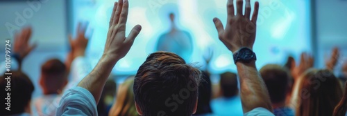 Close-up view of people's backs with hands raised in a conference room