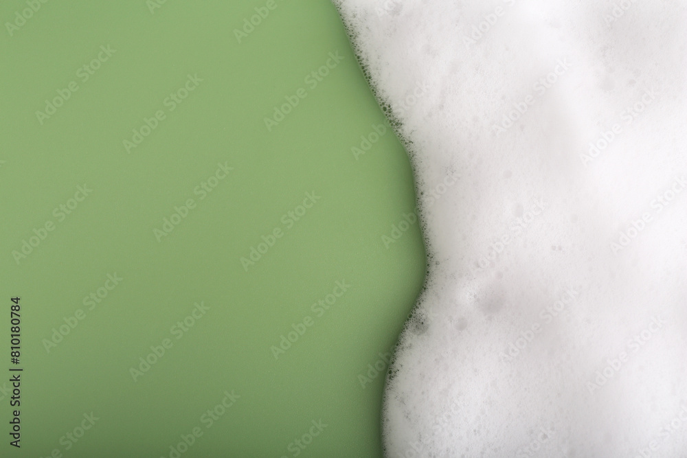 White fluffy foam on green background, top view. Space for text White fluffy foam on green background, top view. Space for text