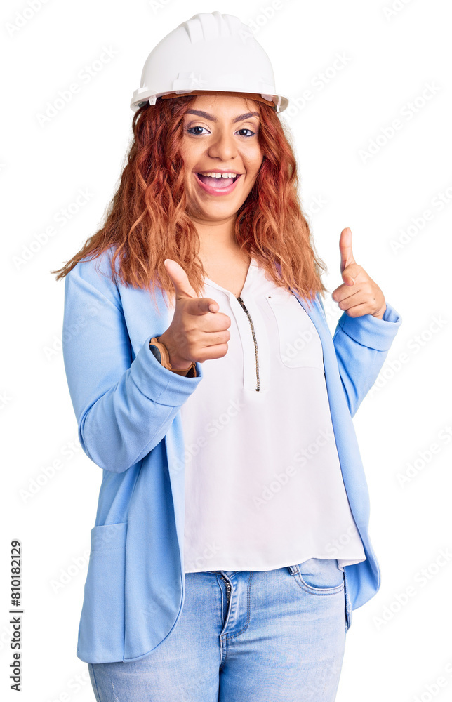 Young latin woman wearing architect hardhat pointing fingers to camera with happy and funny face. good energy and vibes.