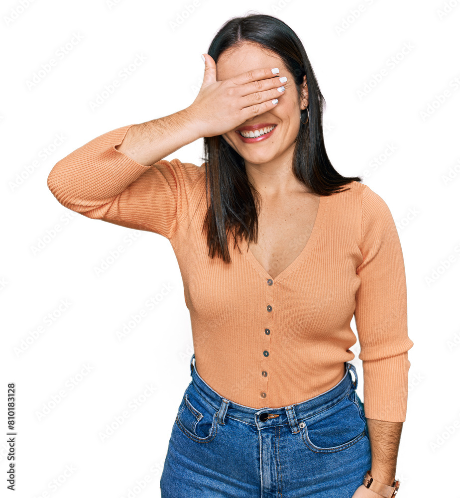 Young hispanic woman wearing casual clothes smiling and laughing with hand on face covering eyes for surprise. blind concept. Young hispanic woman wearing casual clothes smiling and laughing with hand on face covering eyes for surprise. blind concept.