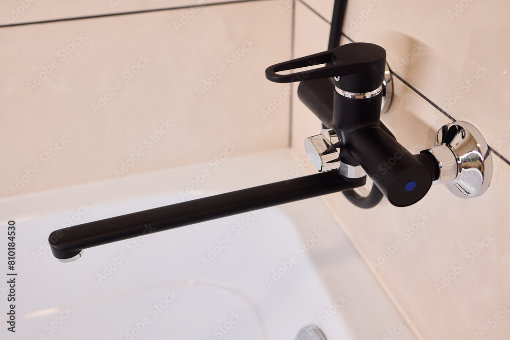 A black faucet complements the white bathtub beautifully A black faucet complements the white bathtub beautifully