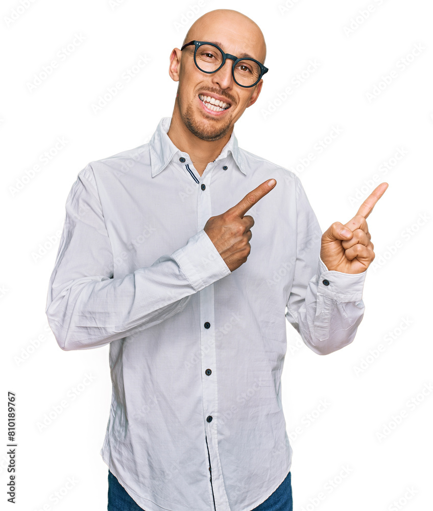 Bald man with beard wearing business shirt and glasses smiling and looking at the camera pointing with two hands and fingers to the side. Bald man with beard wearing business shirt and glasses smiling and looking at the camera pointing with two hands and fingers to the side.