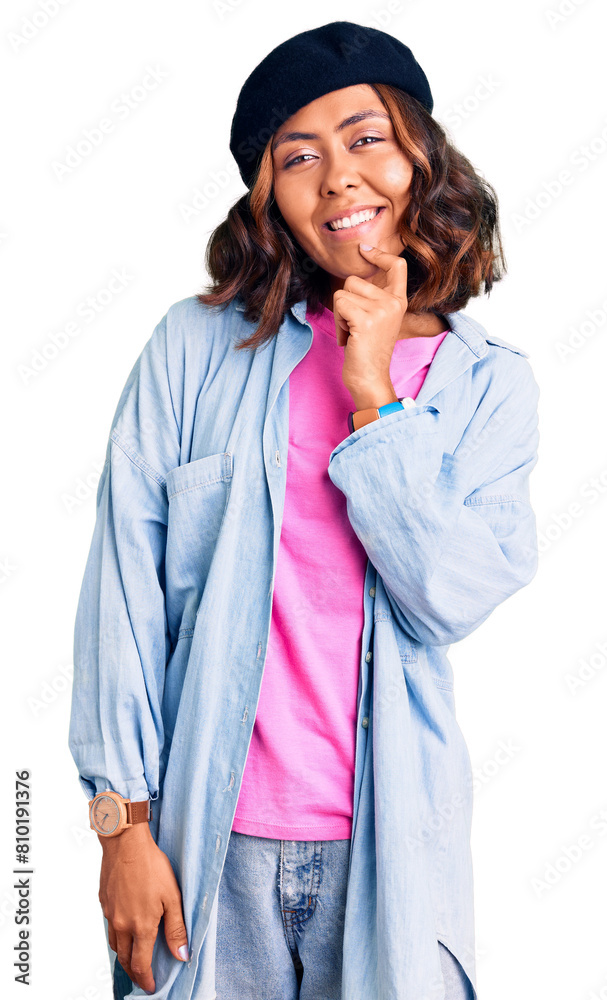 Young beautiful mixed race woman wearing french look with beret looking confident at the camera with smile with crossed arms and hand raised on chin. thinking positive. Young beautiful mixed race woman wearing french look with beret looking confident at the camera with smile with crossed arms and hand raised on chin. thinking positive.