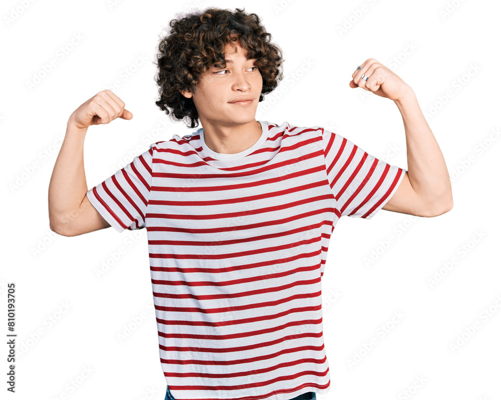 Caucasian teenager wearing casual clothes showing arms muscles smiling proud. fitness concept.