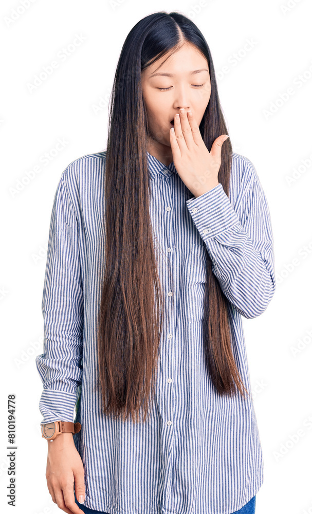 Young beautiful chinese woman wearing casual shirt bored yawning tired covering mouth with hand. restless and sleepiness. Young beautiful chinese woman wearing casual shirt bored yawning tired covering mouth with hand. restless and sleepiness.
