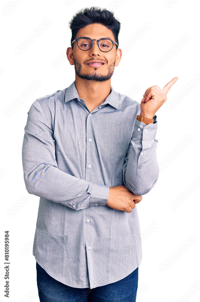 Handsome latin american young man wearing business clothes and glasses smiling happy pointing with hand and finger to the side Handsome latin american young man wearing business clothes and glasses smiling happy pointing with hand and finger to the side