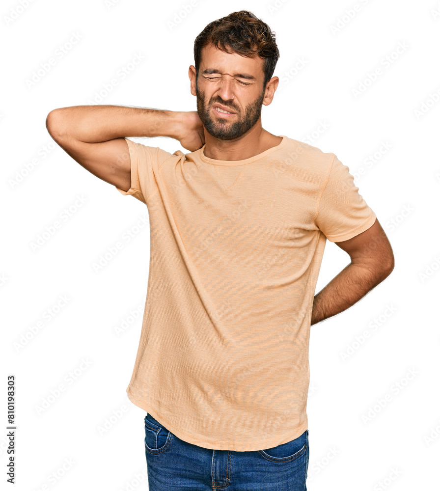 Handsome young man with beard wearing casual tshirt suffering of neck ache injury, touching neck with hand, muscular pain Handsome young man with beard wearing casual tshirt suffering of neck ache injury, touching neck with hand, muscular pain
