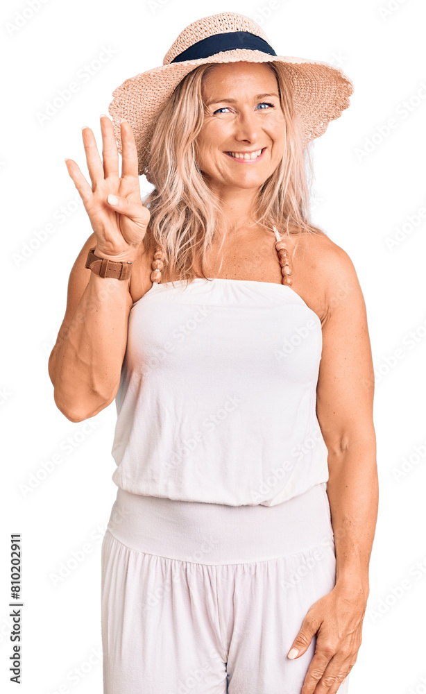 Middle age fit blonde woman wearing summer hat showing and pointing up with fingers number four while smiling confident and happy. Middle age fit blonde woman wearing summer hat showing and pointing up with fingers number four while smiling confident and happy.