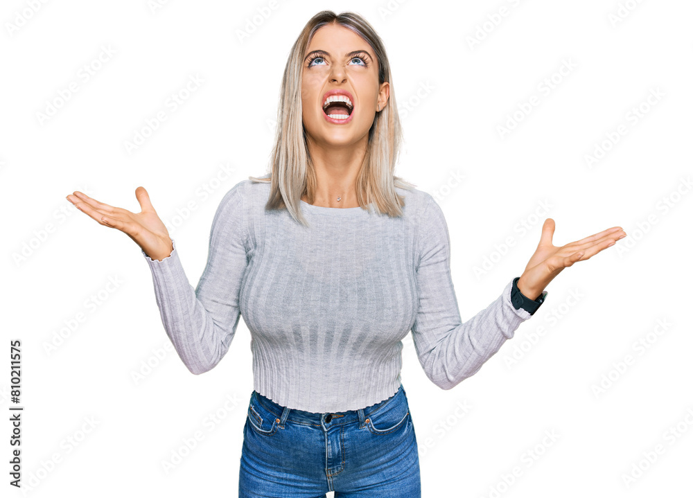 Beautiful blonde woman wearing casual clothes crazy and mad shouting and yelling with aggressive expression and arms raised. frustration concept. Beautiful blonde woman wearing casual clothes crazy and mad shouting and yelling with aggressive expression and arms raised. frustration concept.