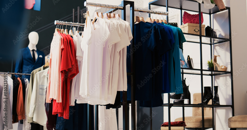 Obraz premium Modern boutique filled with casual wear, multiple racks with fashionable merchandise. Interior of empty clothing store with new fashion colletion on hangers. Small business concept.
