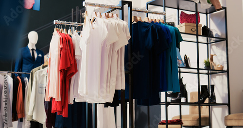 Modern boutique filled with casual wear, multiple racks with fashionable merchandise. Interior of empty clothing store with new fashion colletion on hangers. Small business concept.