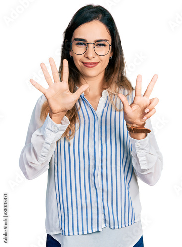 Beautiful hispanic woman wearing casual striped shirt showing and pointing up with fingers number eight while smiling confident and happy. © Krakenimages.com